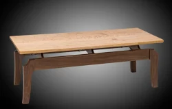 Rectangular wooden coffee table with a light wood top and contrasting darker wood legs against a plain gradient background.