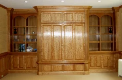 Built-in wooden shelves and cabinets with a large central cupboard and decorative wood grain finish.