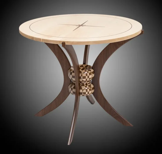 Round wooden table with light top, dark curved legs, and two checkered spherical accents at the center.