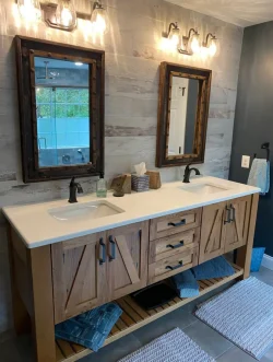Double bathroom vanity with two mirrors, farmhouse-style cabinets, towels on shelves, and lights above each mirror.